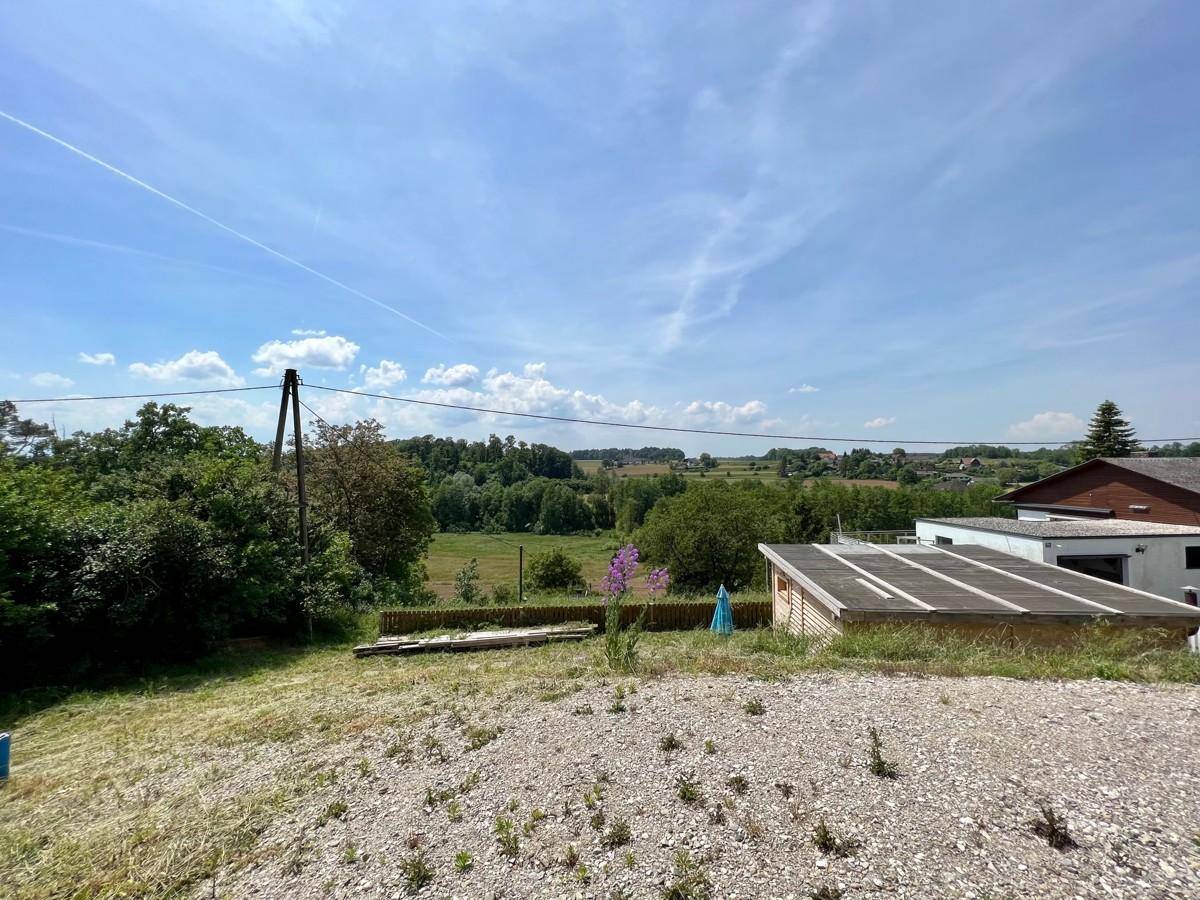 Offenes Grundstück mit einem kleinen Holzschuppen und weitem Blick über die Landschaft.