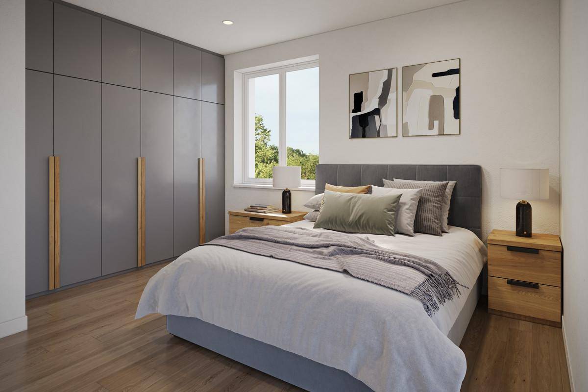 Modernes Schlafzimmer mit großem Einbauschrank, hellem Holzboden und Blick ins Grüne.
