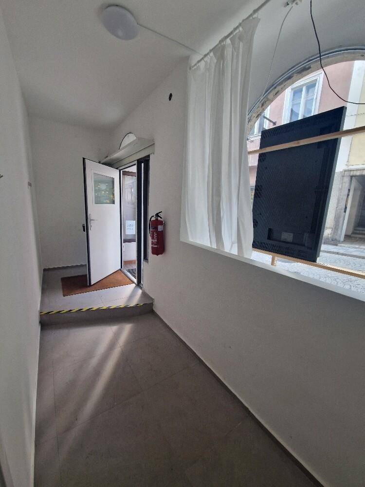 Eingangsbereich mit Fliesenboden, offener Tür und Blick auf die Straße.