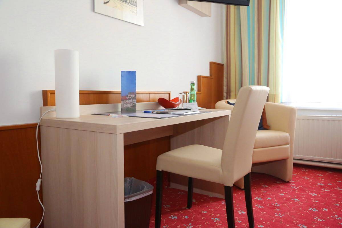 Schreibtischbereich in einem Schlafzimmer mit Stuhl und Blick auf das Fenster.