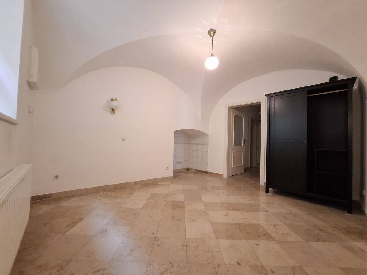 Geräumiger Raum mit Gewölbedecke, Fliesenboden und einem großen Kleiderschrank.