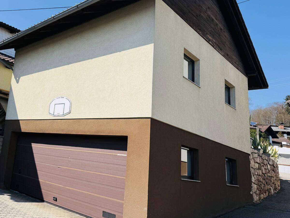 Seitenansicht der Doppelgarage mit Basketballkorb und gepflegter Außenanlage.