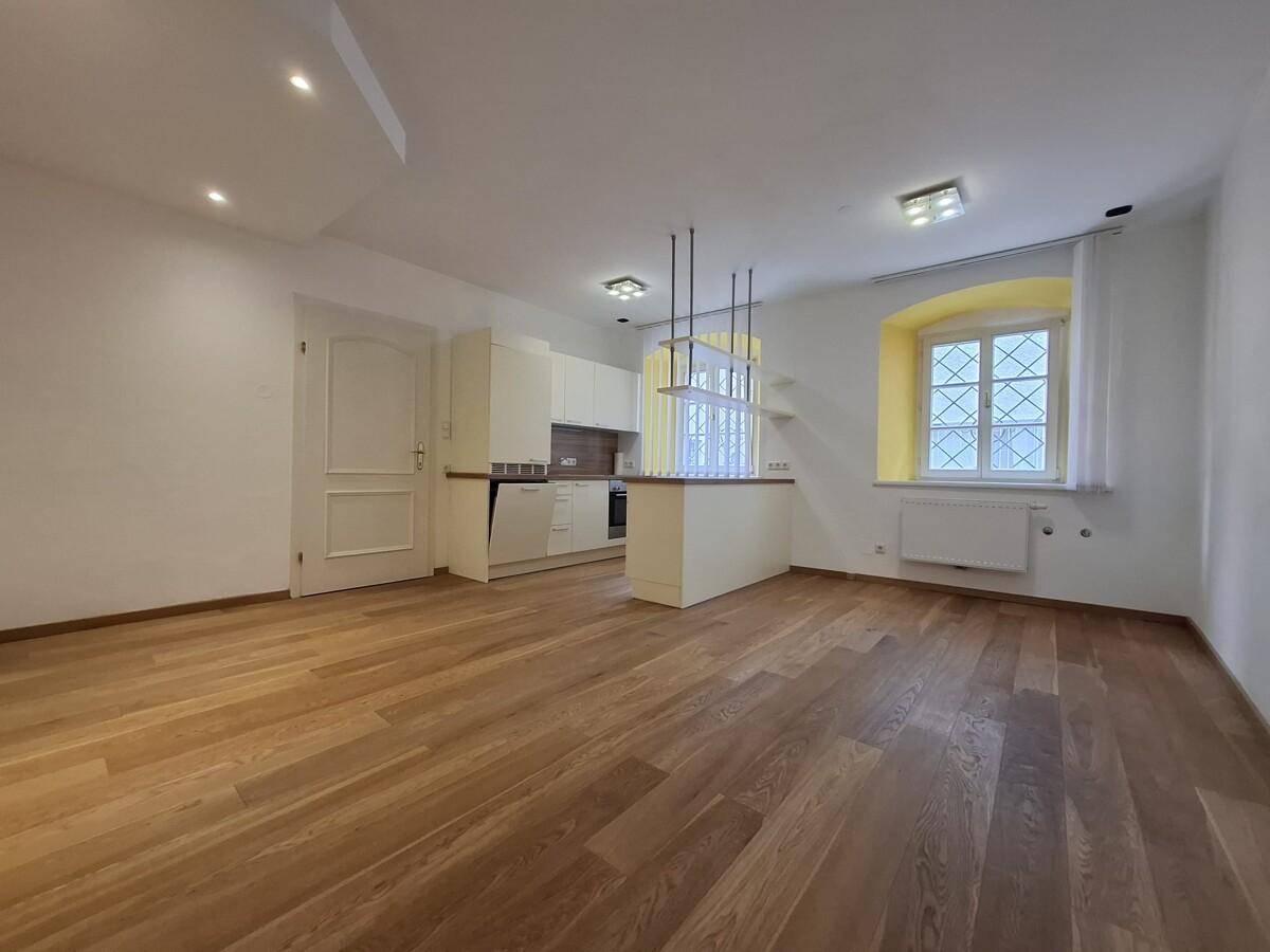 Geräumiger Wohn- und Essbereich mit Holzboden und einer funktionalen Kücheninsel.