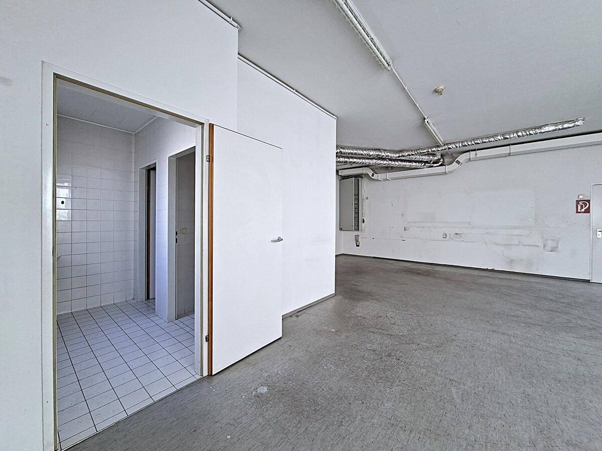 Gefliester Umkleideraum oder Sanitärbereich neben dem Lagerraum, funktional und sauber.