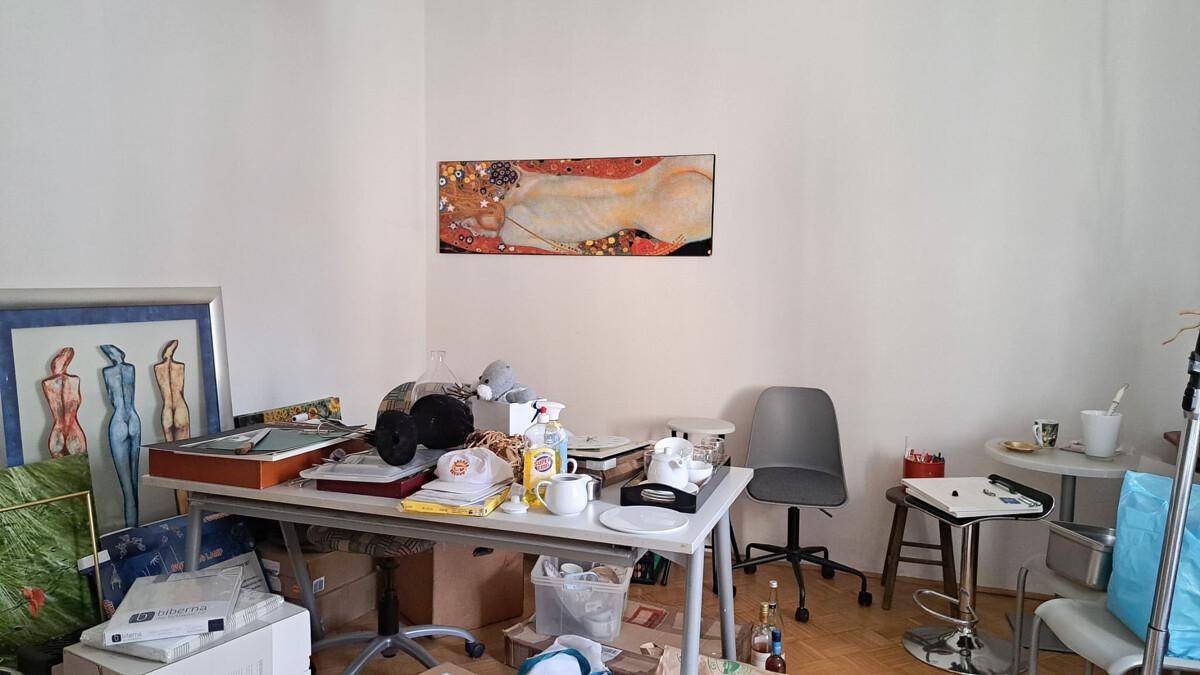 Arbeitszimmer mit Schreibtisch, Stühlen und verschiedenen Kunstwerken an den Wänden.