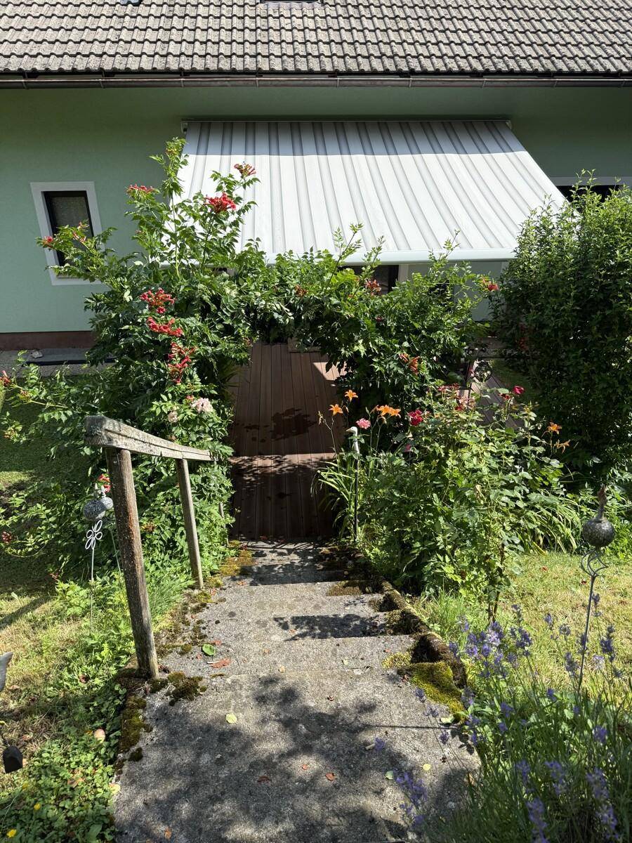 Steintreppe im Garten, umgeben von üppiger Vegetation und Blumen.