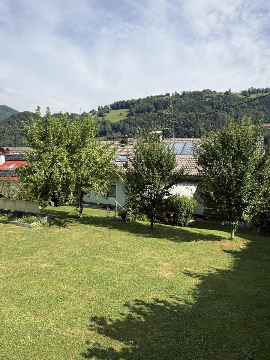 Großer, gepflegter Garten mit Rasenfläche und Bäumen vor dem Haus.