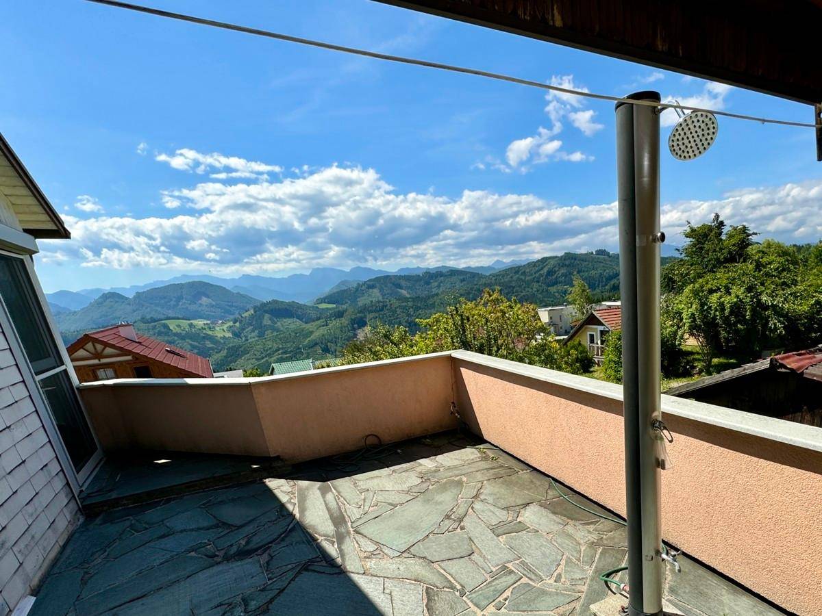 Große Terrasse mit Steinplattenboden und weitem Panoramablick auf die Berge.