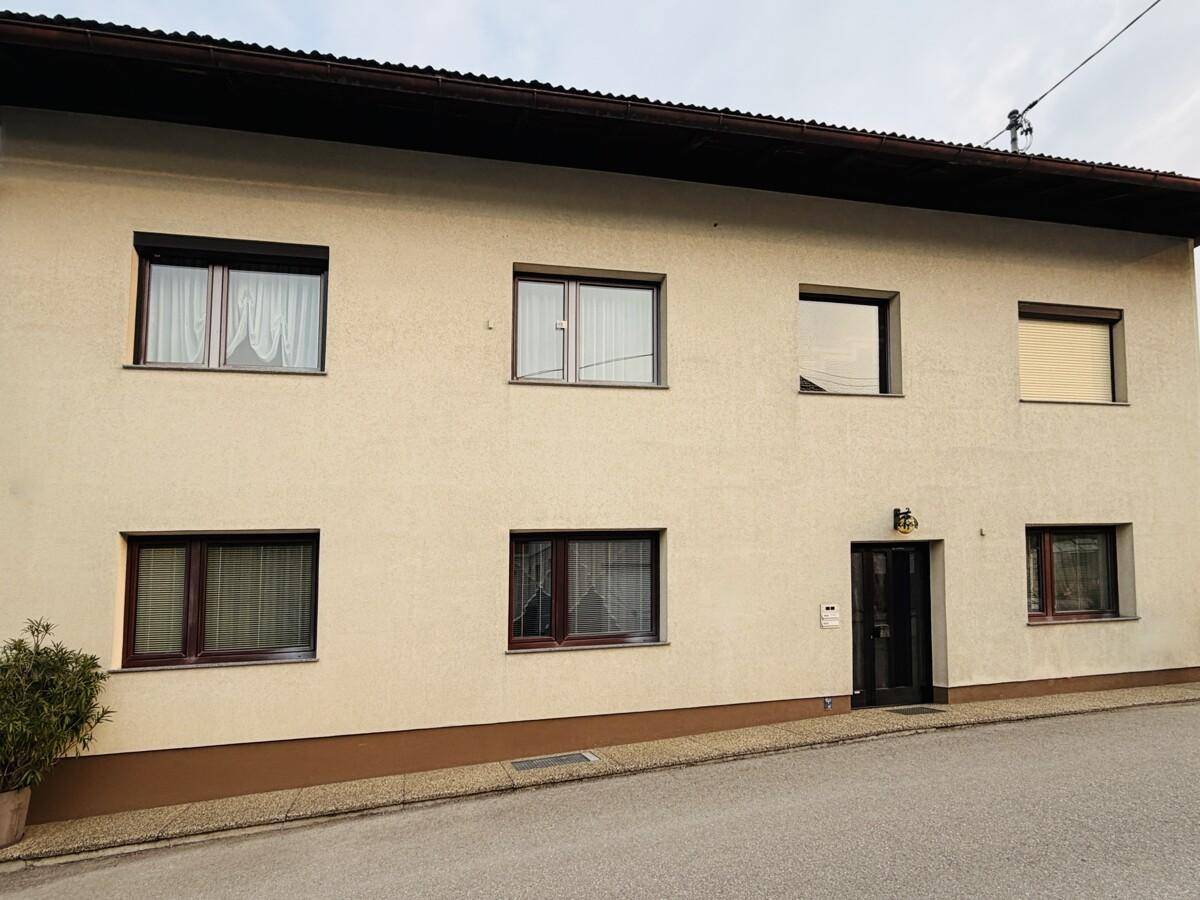 Vorderansicht des Zweifamilienhauses mit mehreren Fenstern und Eingangsbereich.