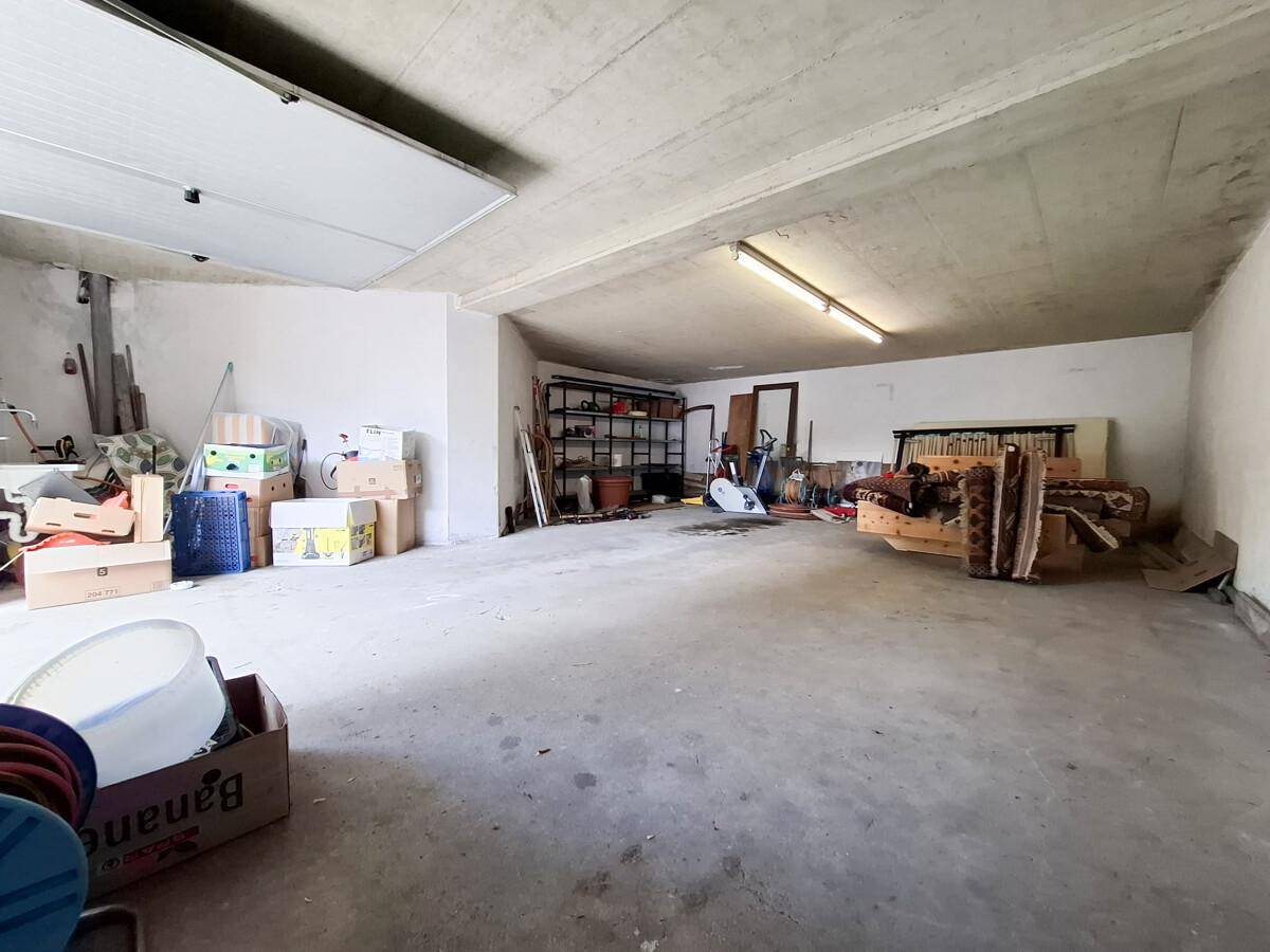 Große Garage mit Betonboden und viel Stauraum, ideal für Fahrzeuge und Lagerung.