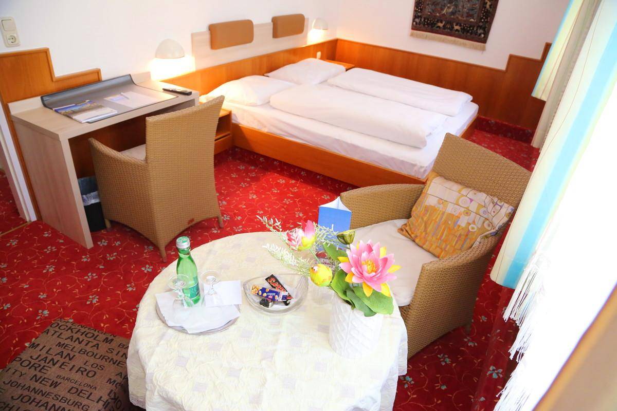 Geräumiges Schlafzimmer mit Doppelbett, Schreibtisch und gemütlicher Sitzecke.