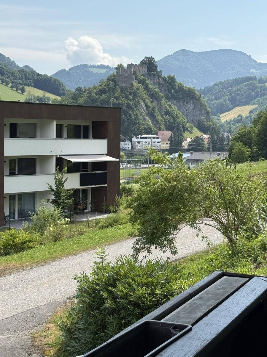 Panoramablick auf die umliegende Berglandschaft und ein Gebäude im Tal.
