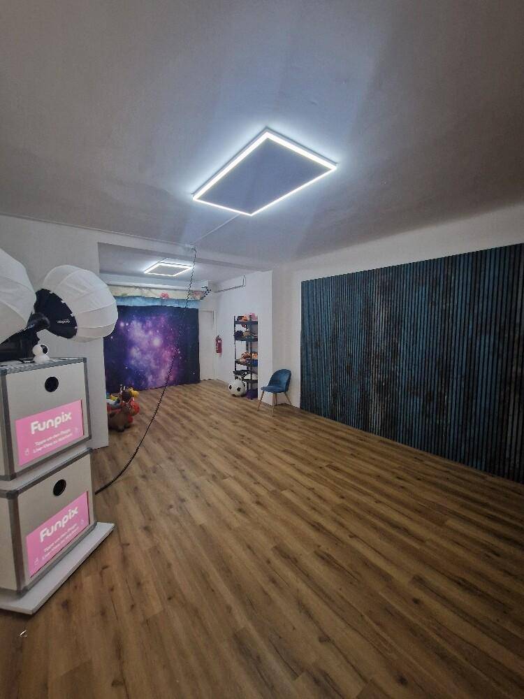 Weitläufiger Raum mit Holzboden und dekorativer Wandgestaltung, beleuchtet durch moderne Leuchten.
