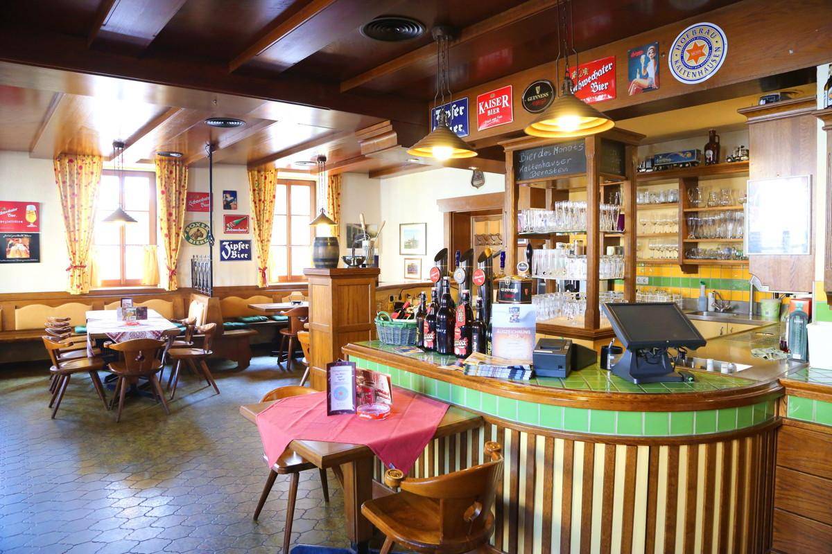 Gemütlicher Restaurantbereich mit Holzvertäfelung, Bar und traditionellen Sitzgelegenheiten.