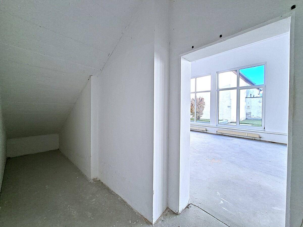 Kleiner Abstellraum oder Flurbereich mit schrägen Wänden und Zugang zum Hauptraum.