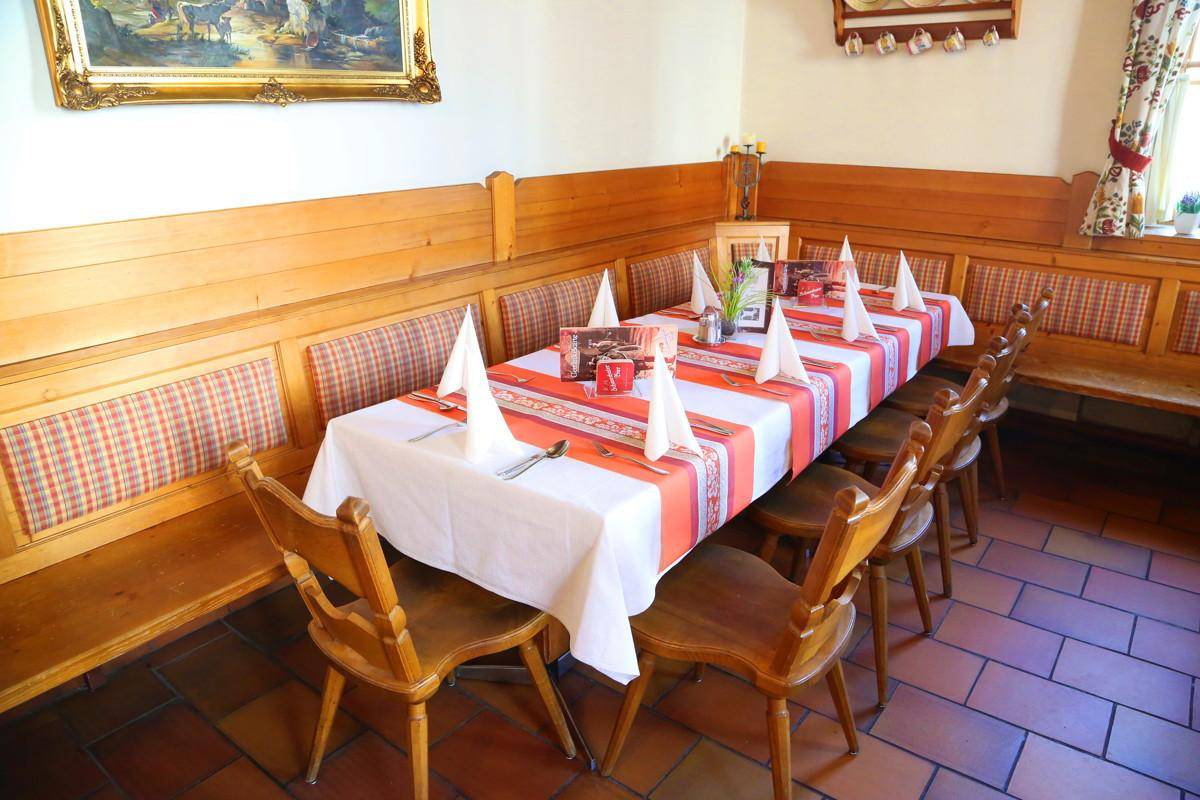 Langer Esstisch mit festlicher Dekoration und Holzbänken in einem traditionellen Restaurant.