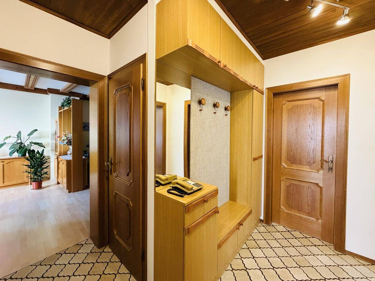 Eingangsbereich mit Garderobe, Spiegel und Fliesenboden im traditionellen Stil.