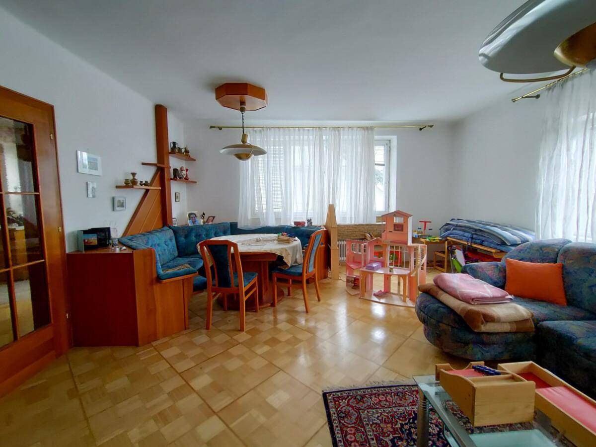 Heller Wohn- und Essbereich mit Eckbank, Sofa und Fliesenboden, ideal für Familien.