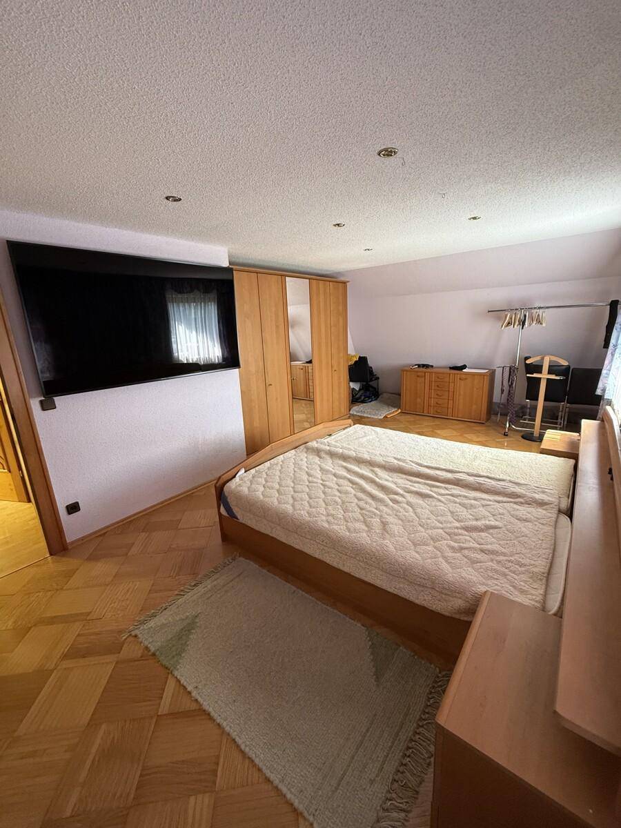 Geräumiges Schlafzimmer mit Holzboden, großem Bett und Einbauschränken.