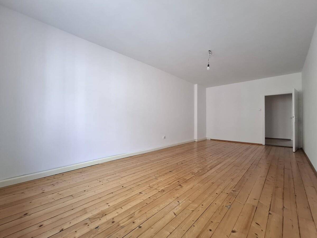 Heller Raum mit Holzdielenboden und offenem Durchgang, ideal für eine flexible Raumgestaltung.