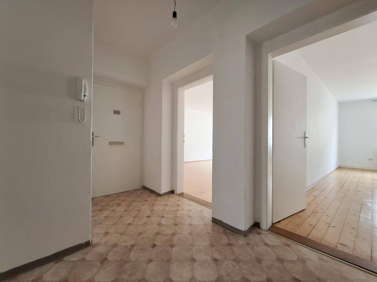 Flur mit gemustertem Fliesenboden und Zugang zu verschiedenen Zimmern, inklusive Gegensprechanlage.