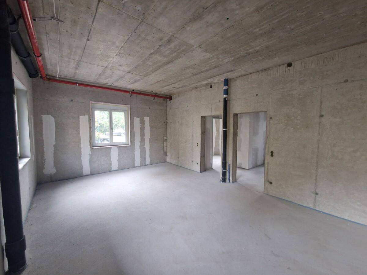 Unfertiger Innenraum mit Sichtbetonwänden und -decke, bereit für den Ausbau.