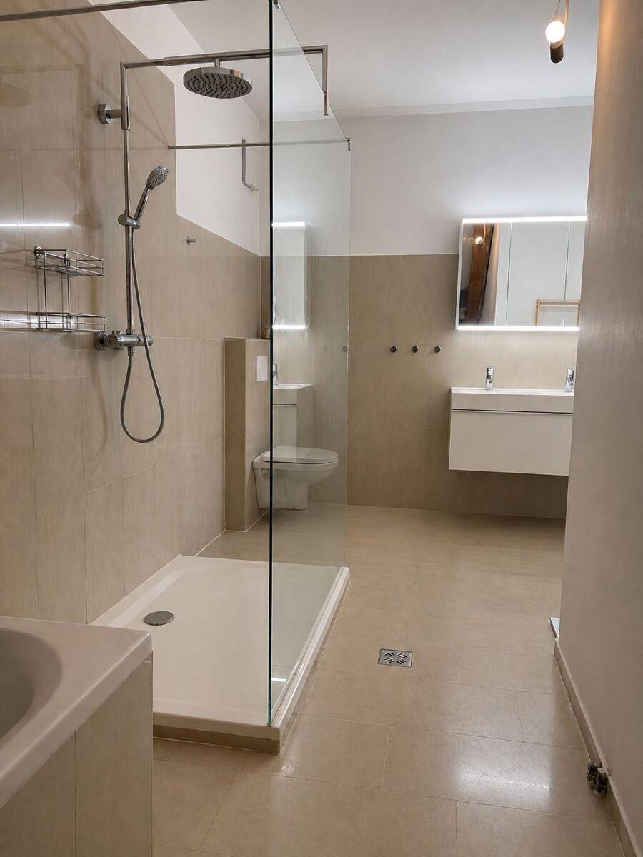 Helles Badezimmer mit begehbarer Dusche, Badewanne und modernen Armaturen.