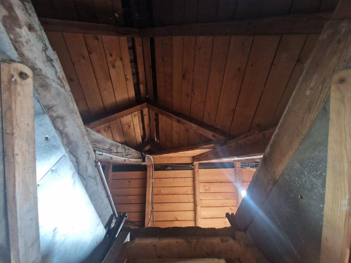 Blick in den unfertigen Dachboden mit sichtbaren Holzbalken und der Dachkonstruktion.