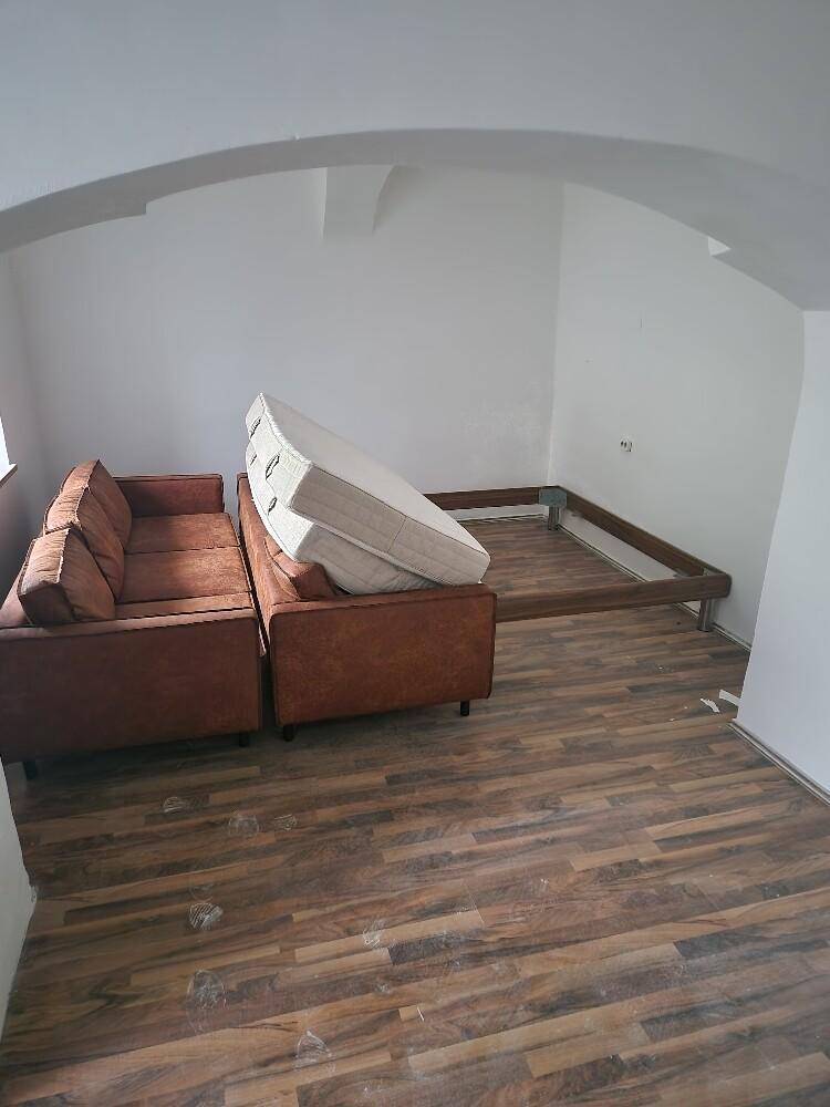 Geräumiger Raum mit Holzboden und gewölbter Decke, vorbereitet für die Einrichtung.