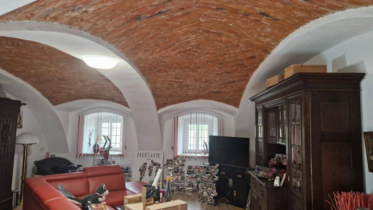 Wohnzimmer mit beeindruckender Gewölbedecke aus Ziegeln und traditionellen Möbeln, die Charakter verleihen.