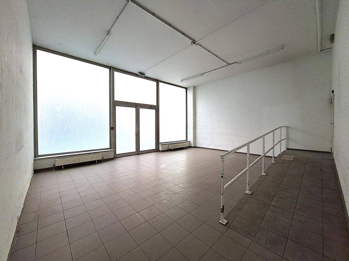 Gewerbefläche mit Fliesenboden, großen Fenstern und einer Rampe, vielseitig nutzbar.