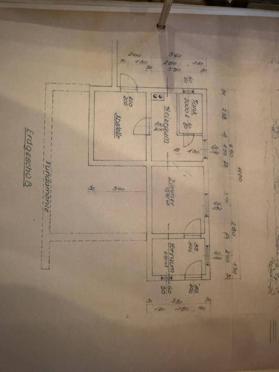 Handgezeichneter Grundriss des Erdgeschosses oder Fundaments mit Raumaufteilung und Heizraum.