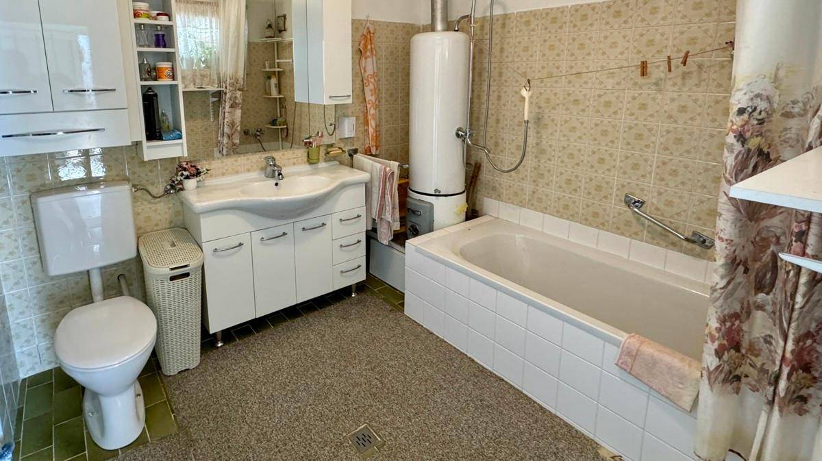 Geräumiges Badezimmer mit Badewanne, WC und Fliesen im traditionellen Stil.