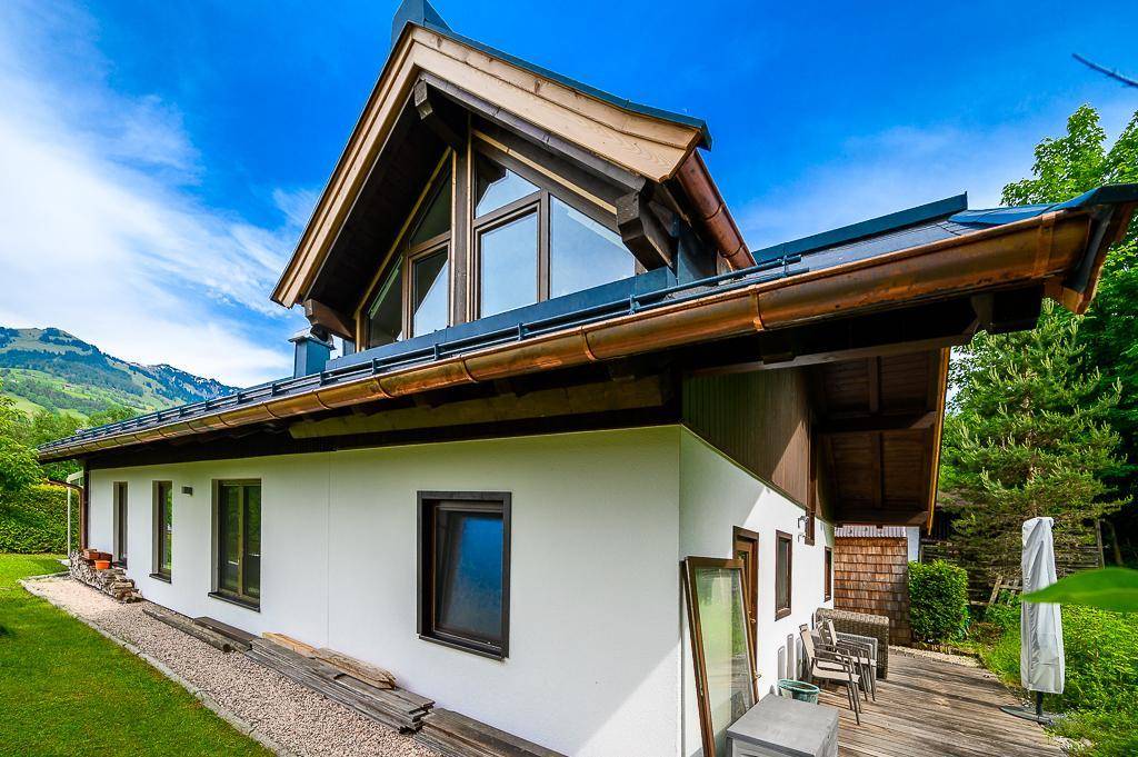 Attraktives Haus mit Satteldach, großen Fenstern und gepflegter Außenanlage.