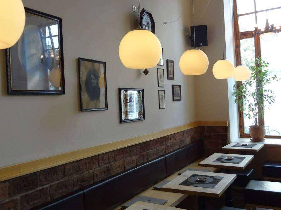 Detailansicht der Sitzbänke, Wanddekoration und eines großen Fensters im Gastraum.