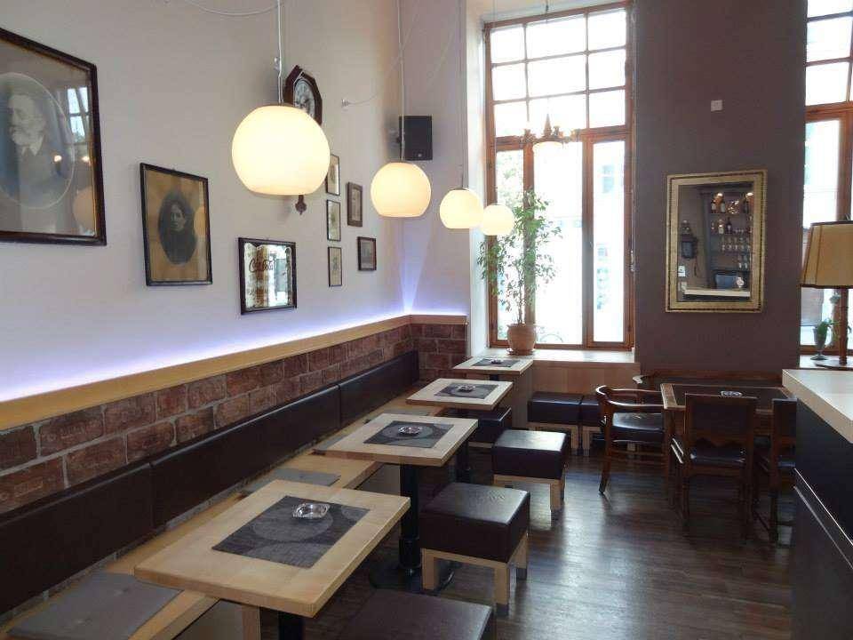 Detailansicht der Sitzbänke, Wanddekoration und eines großen Fensters im Gastraum.