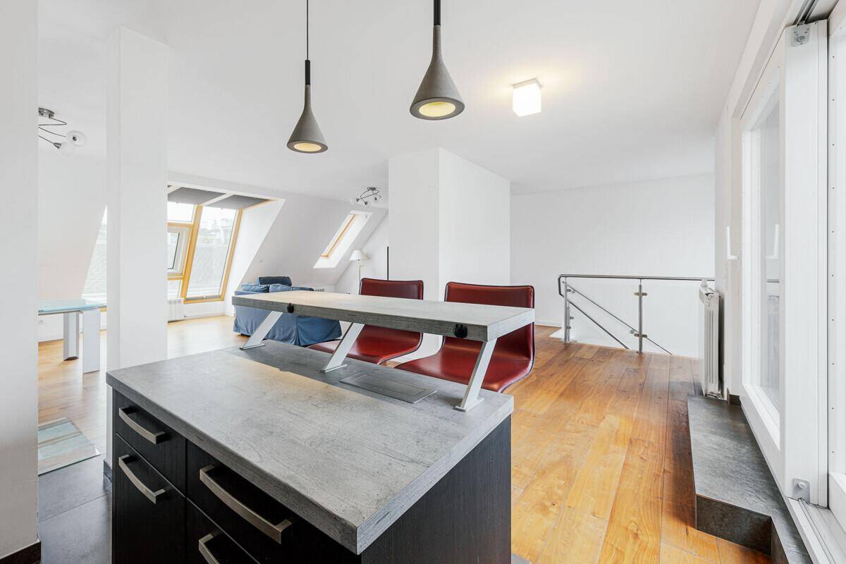 Heller Wohnbereich mit Holzboden, moderner Treppe und Blick auf die schrägen Dachfenster.