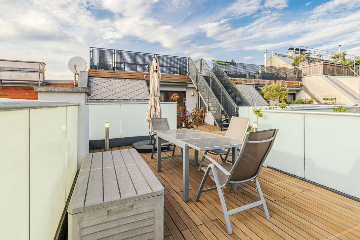 Gemütliche Dachterrasse mit Esstisch, Sitzgelegenheiten und Pflanzen für Mahlzeiten im Freien.