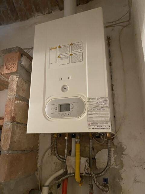 Hauswirtschaftsraum mit einem Wandheizkessel und sichtbaren Rohrleitungen, der die Warmwasserversorgung sicherstellt.