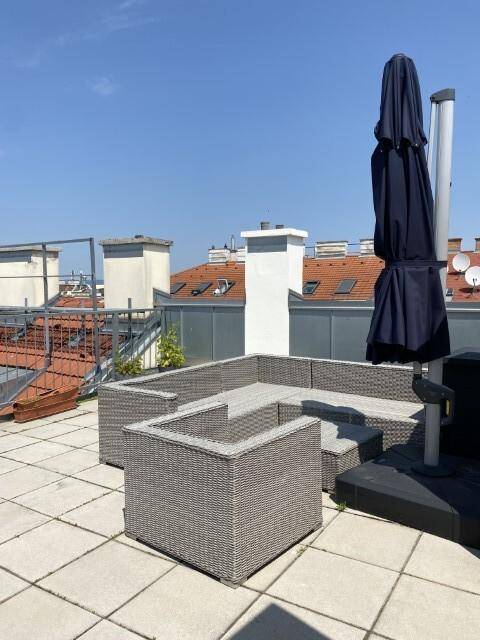Sonnige Dachterrasse mit bequemen Loungemöbeln und weitem Blick über die Dächer.