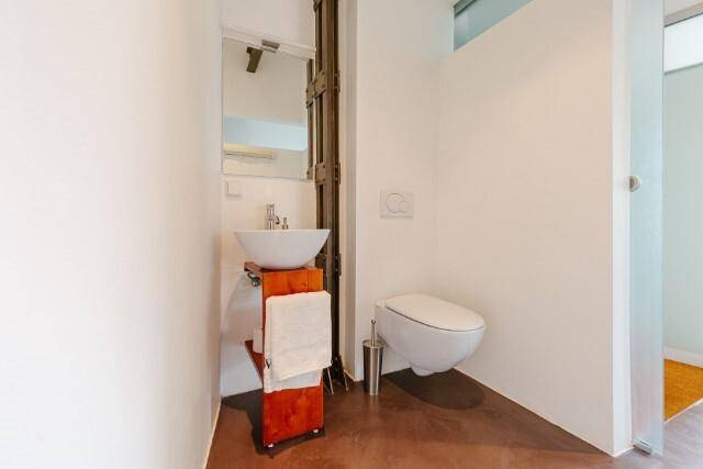 Kleines WC mit Aufsatzwaschbecken und wandhängender Toilette in schlichtem Design.