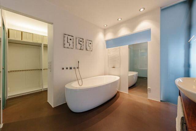Elegantes Badezimmer mit freistehender Badewanne und Zugang zu einem begehbaren Kleiderschrank.