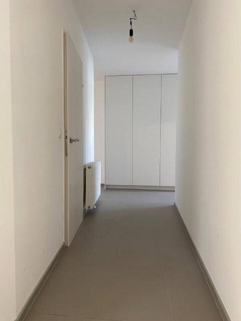 Funktionaler Flur mit Einbauschränken, Fliesenboden und Heizkörper, bietet viel Stauraum.