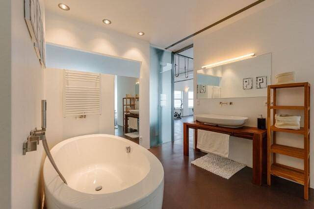 Elegantes Badezimmer mit freistehender runder Badewanne und modernem Waschbeckenbereich.