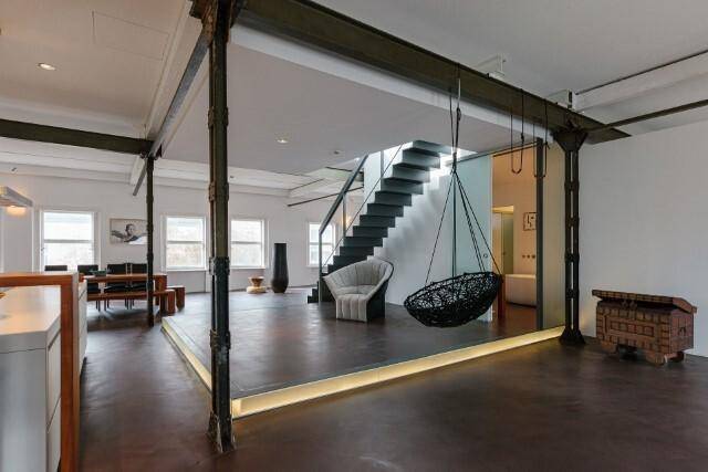 Weitläufiger Loft-Wohnbereich mit offener Küche, Essbereich und moderner Treppe.