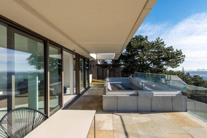 Elegante Terrasse mit Pool, großen Schiebetüren und weitem Ausblick, ideal für Entspannung im Freien.
