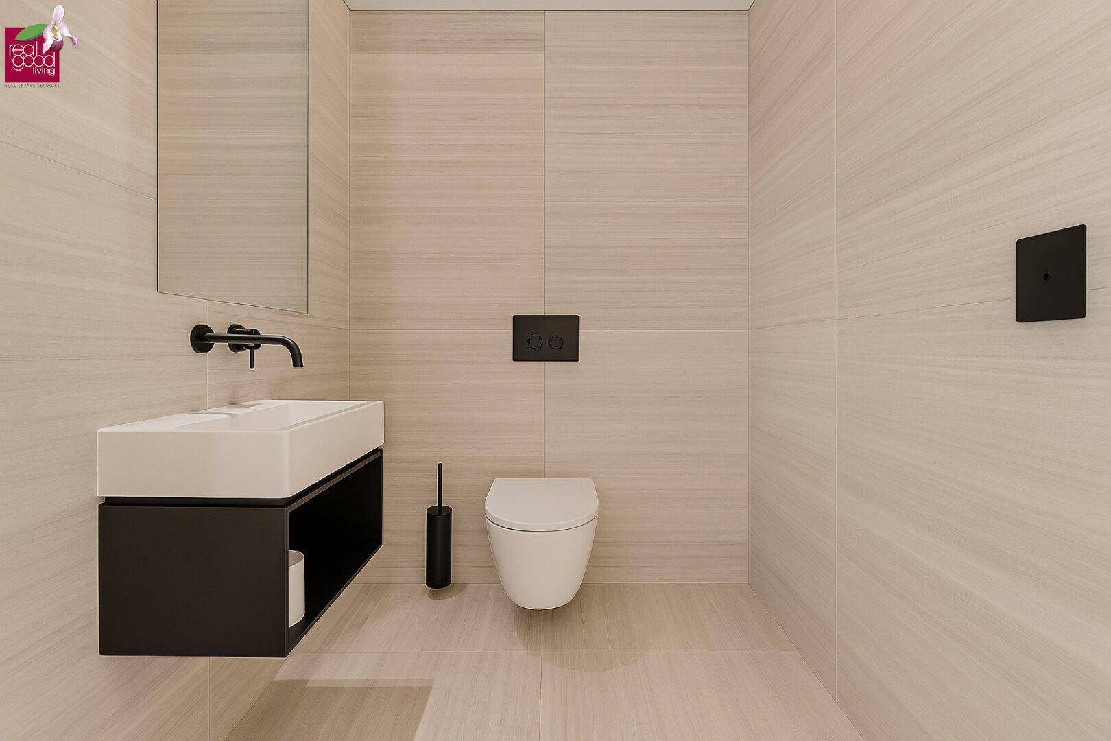 Modernes WC mit wandhängender Toilette und minimalistischem Waschbecken.