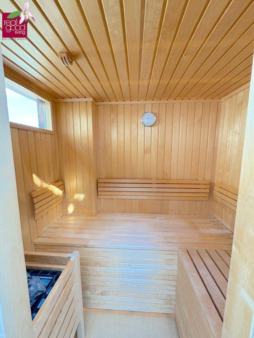 Gemütliche Holzsauna mit Sitzbänken und Saunaofen, ideal zur Entspannung und Wellness.