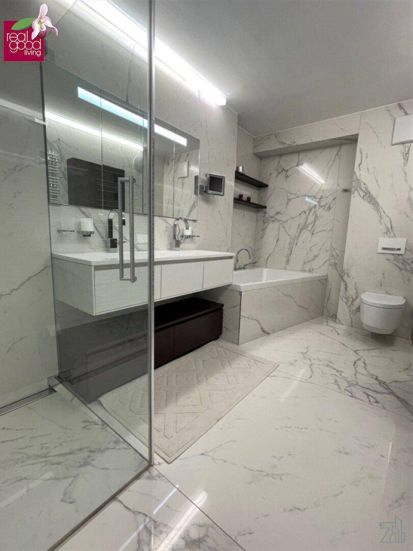 Modernes Badezimmer mit begehbarer Dusche, Badewanne und luxuriösen Marmoroberflächen.