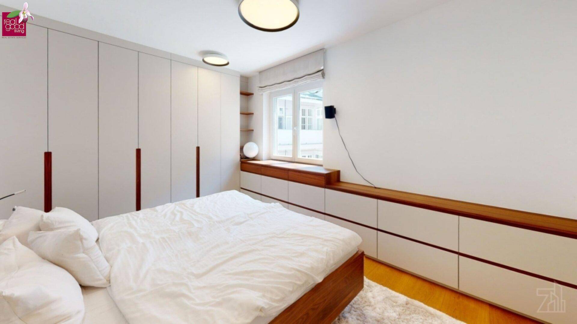 Helles Schlafzimmer mit maßgefertigten Einbauschränken und Holzboden.